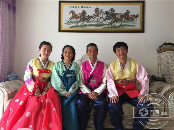 董瑞吉一家人穿着民族服装合影，他们是朝鲜族文化的传承人，始终不忘发扬光大朝鲜族的文化，董瑞吉本人更是创作了许多家乡人喜爱的朝鲜族歌曲.jpg