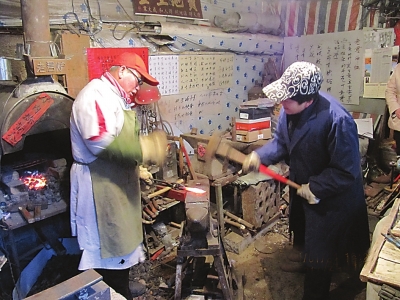 记者(右)与老铁匠师傅打对锤。.jpg